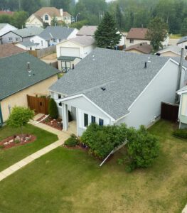Aerial view of a residential neighborhood with houses, green lawns, and landscaped gardens.